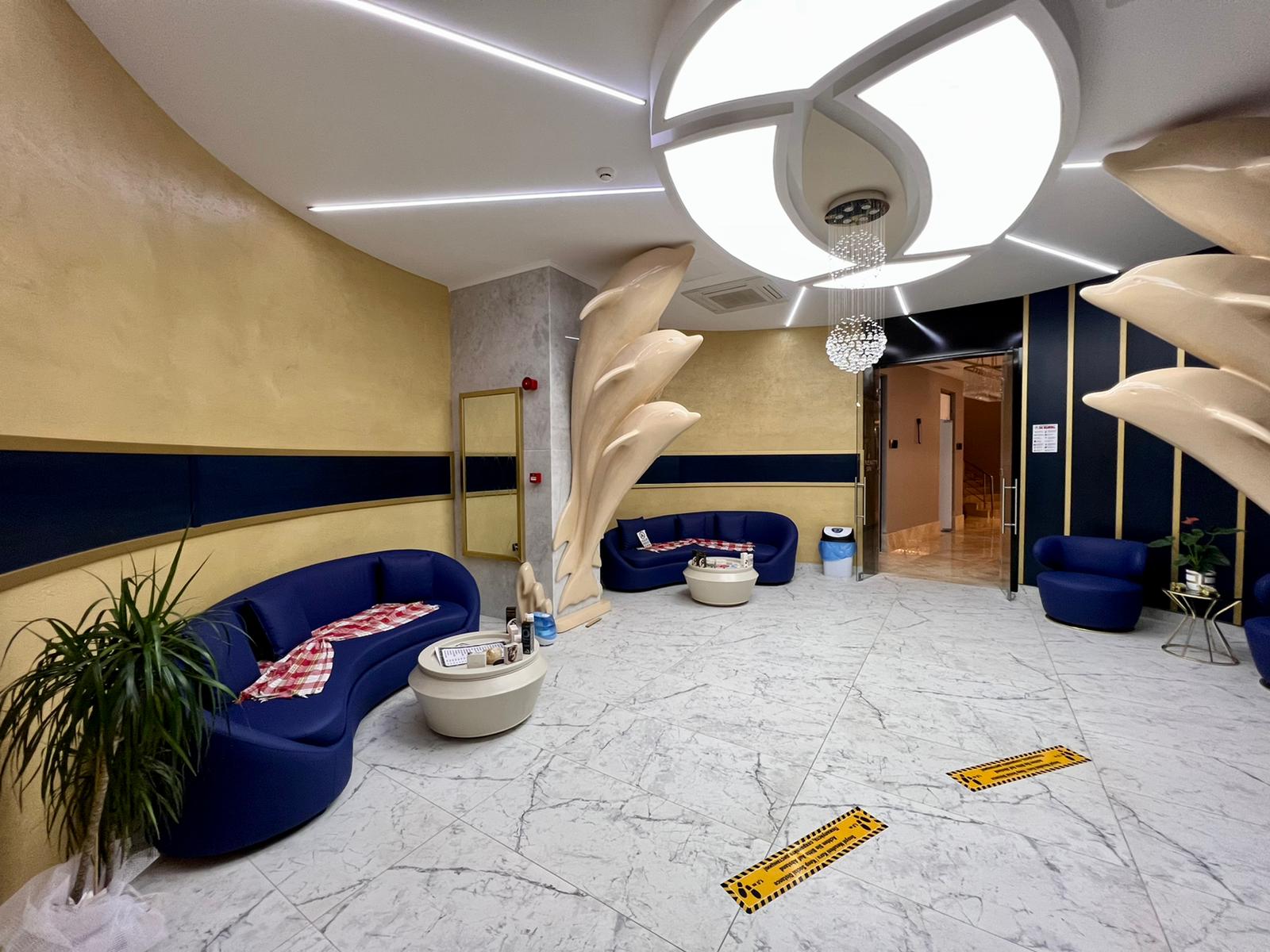 Blue sofas and round tables in a lobby in a complex with apartments in Mahmutlar, Turkey