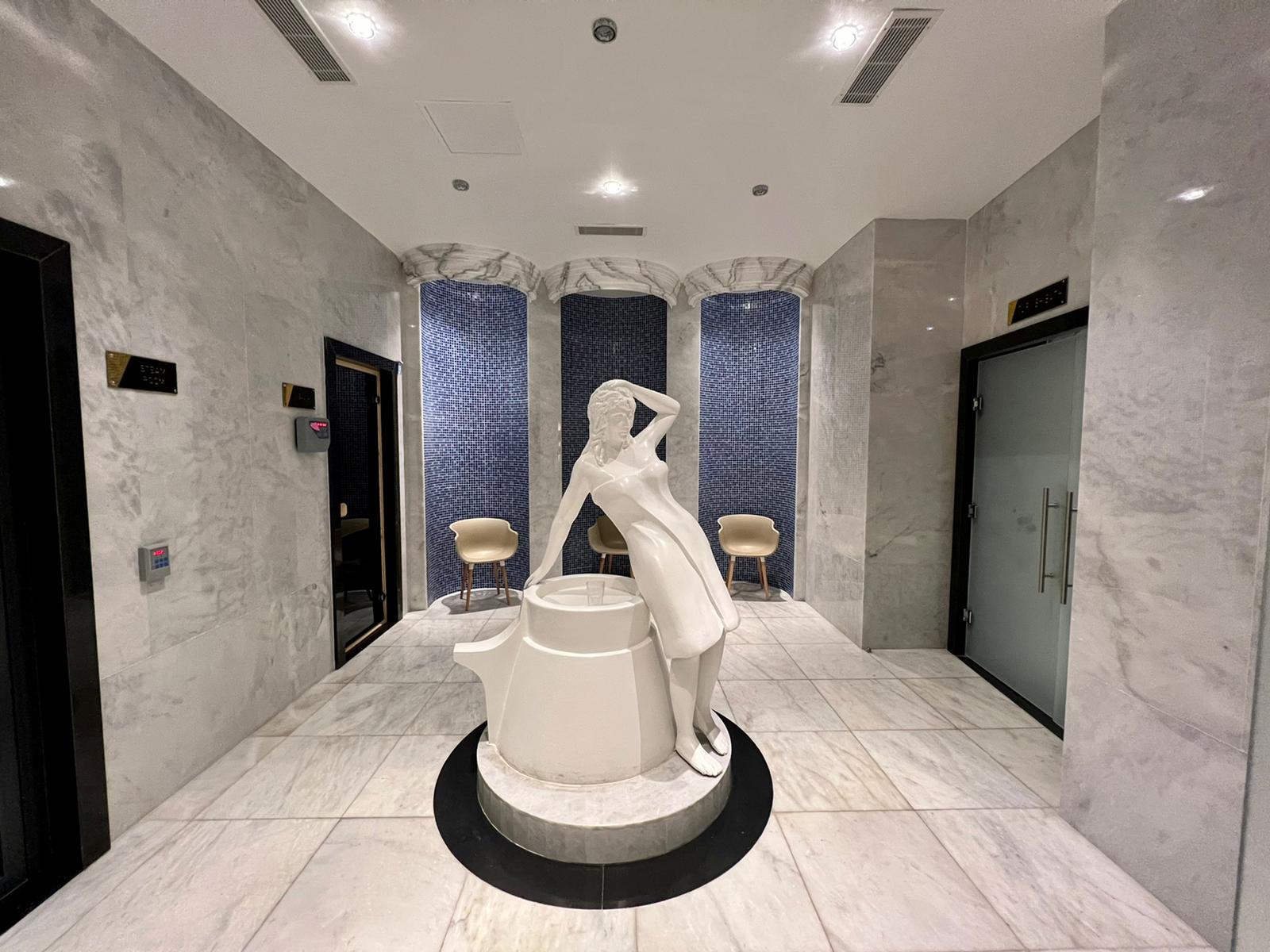 Spa area with marble walls a central bowl and blue mosaic niches in Mahmutlar