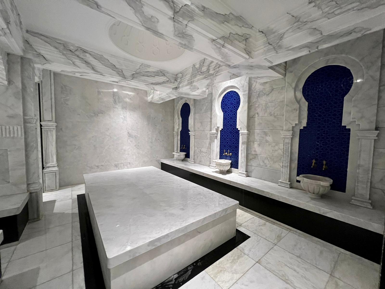 Hammam with a marble platform and blue mosaic niches in a complex with apartments