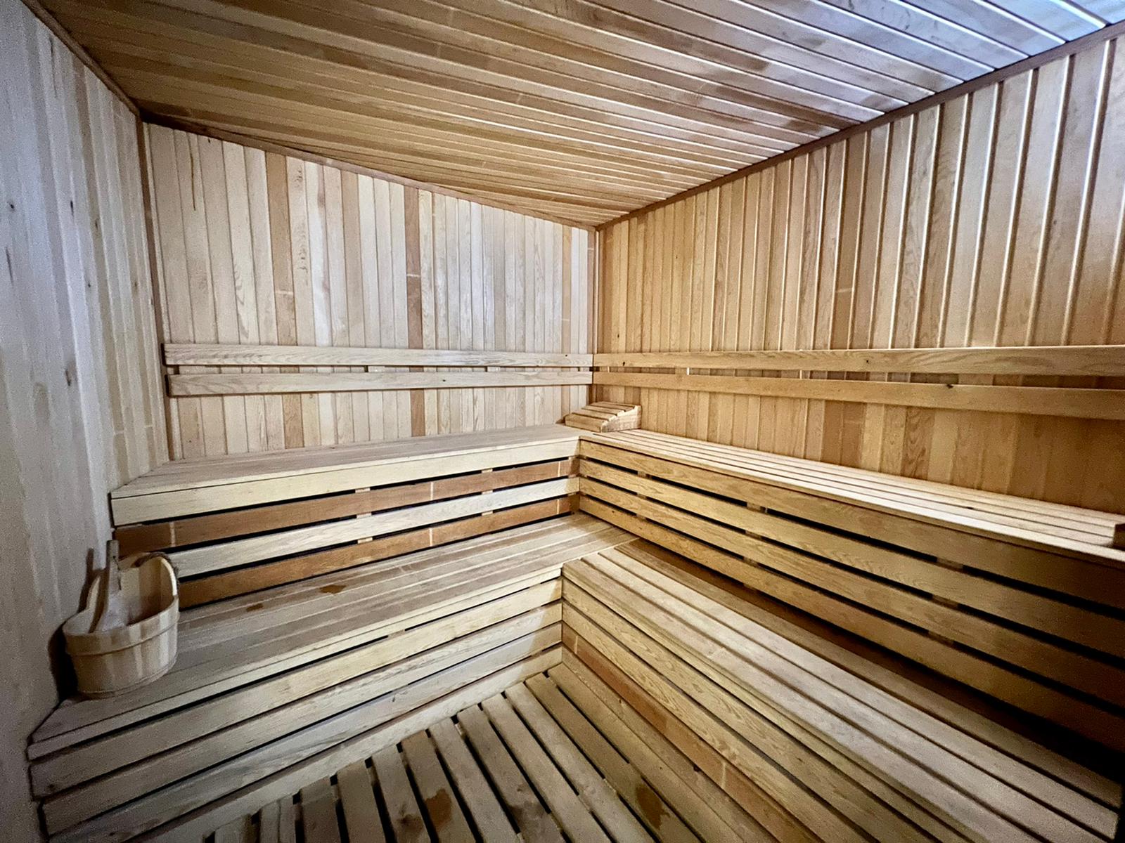 Sauna with wooden benches and a slatted ceiling in a residence in Mahmutlar