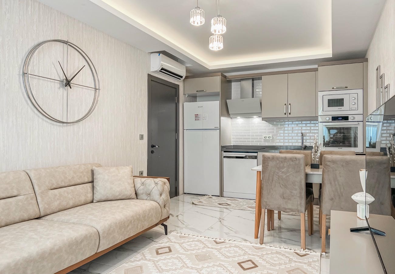 Kitchen-living room in Mahmutlar with corner cabinetry, sofa and dining table