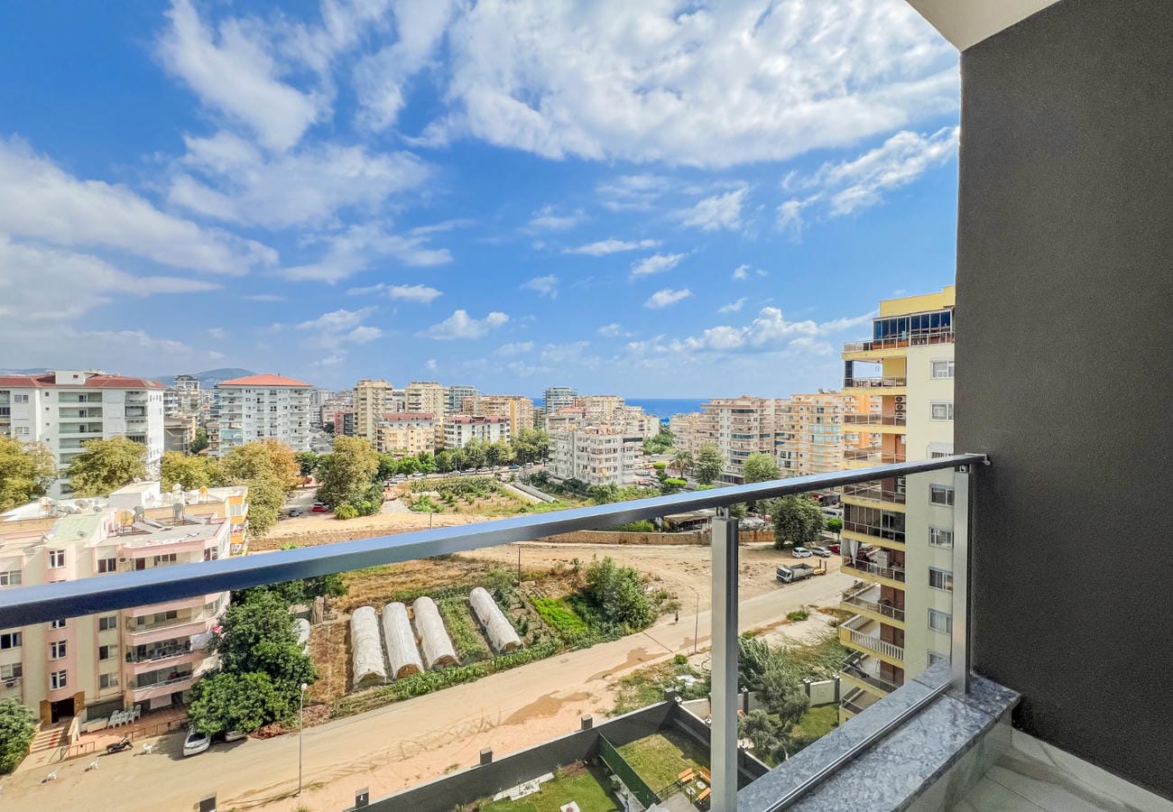 Apartment balcony with panoramic city view and a strip of sea on the horizon