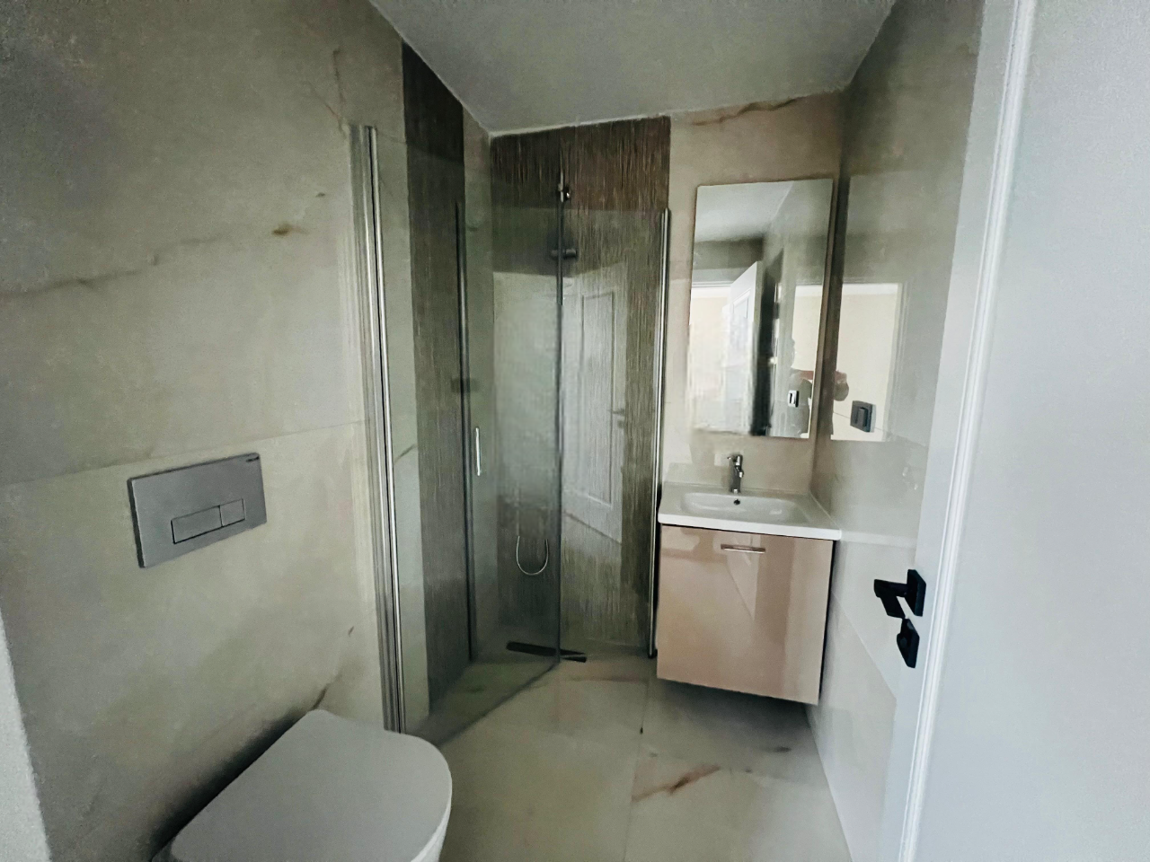 Cam duş kabinli banyo Konaklı’daki konutta asma klozet ve lavaboyla