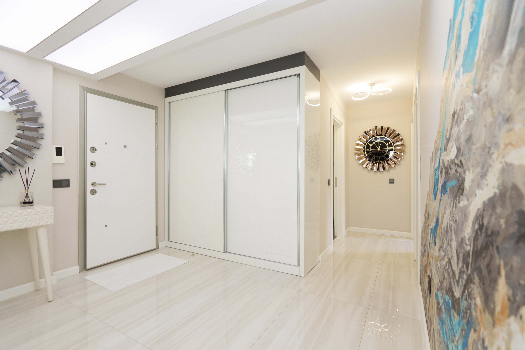 Entry hall with a built-in wardrobe, round mirror and glossy light floor in Kargicak