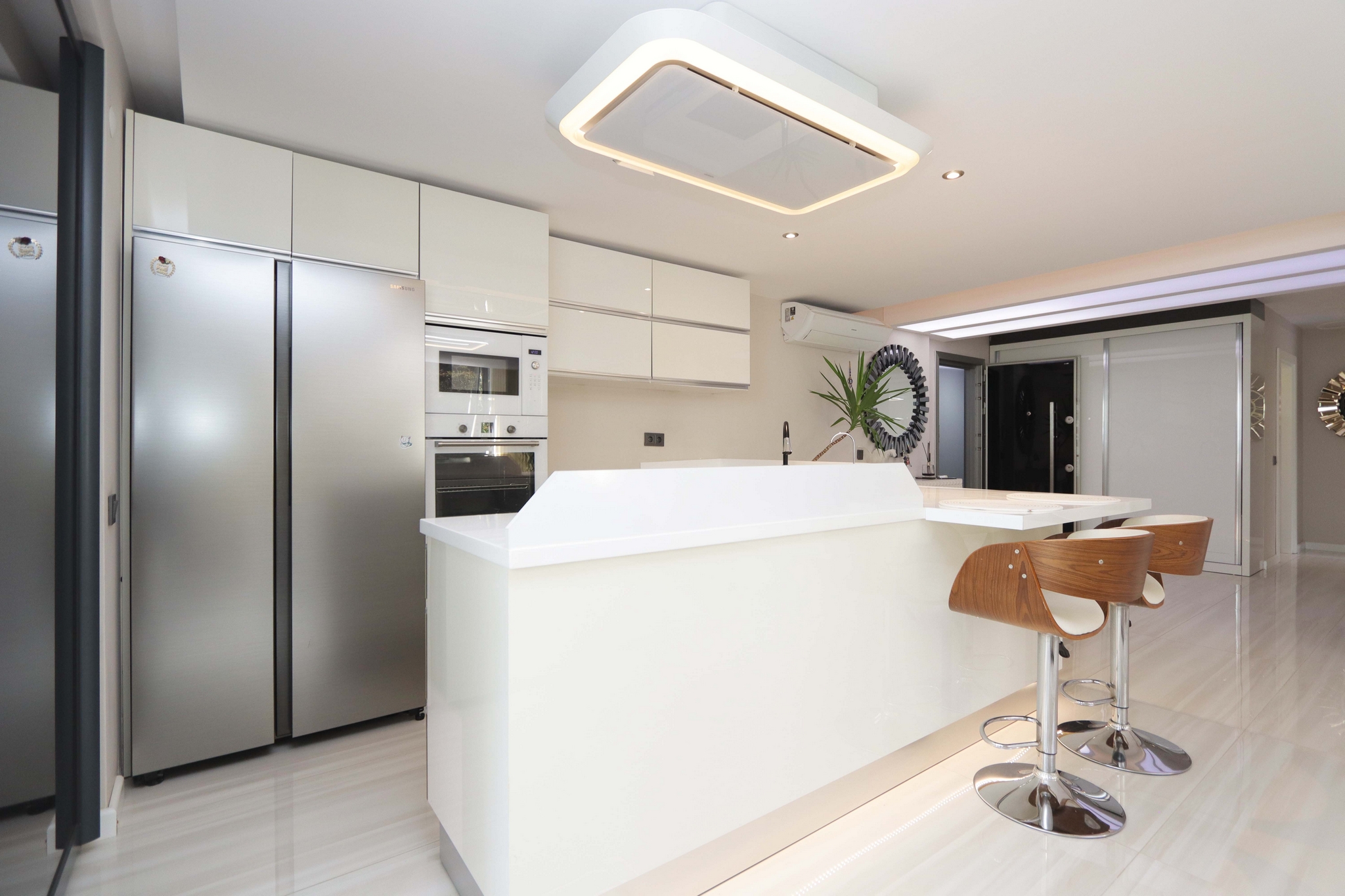 Kitchen-living room with an island, refrigerator and built-in appliances in a flat in Kargicak