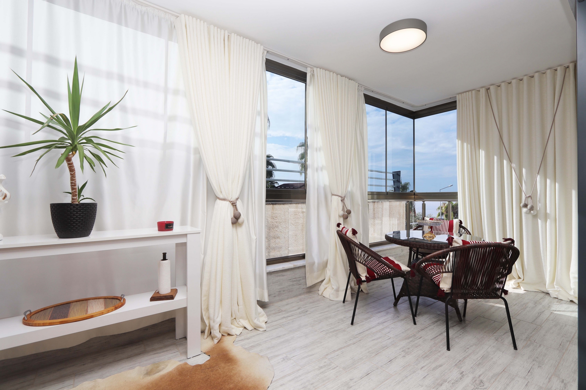 Glazed corner terrace with dining set, panoramic windows and sea views in a residence for sale in Turkey