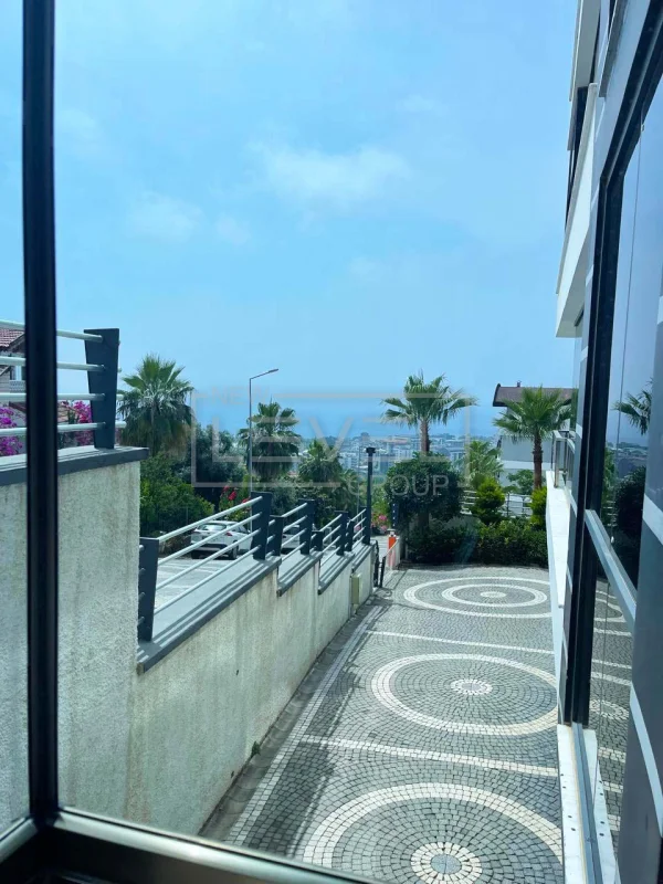 Deniz manzaralı palmiyeli yol Türkiye'de satılık dairelerin bulunduğu binanın girişinde