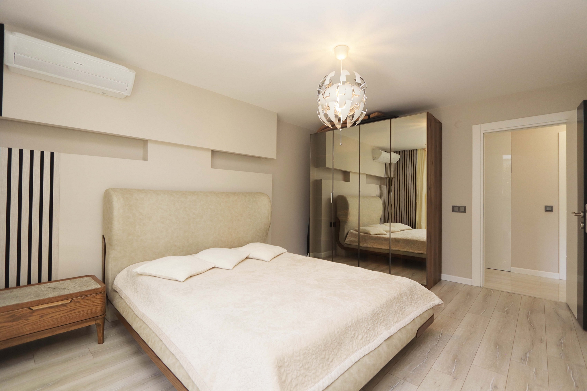 Bedroom with a double bed, mirrored wardrobe and bedside table in a 2+1 residence