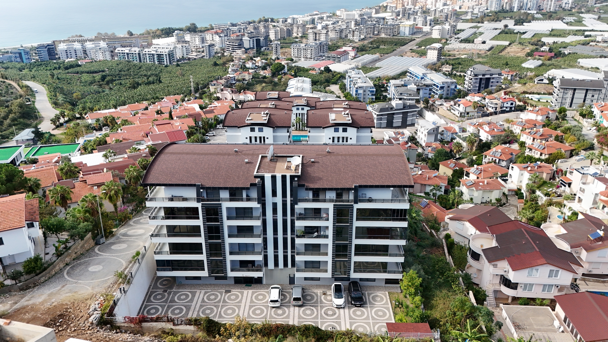 Dairesatışındaki konutların otoparklı cephesi ve yüzme havuzu Türkiye'deki sitede görülüyor