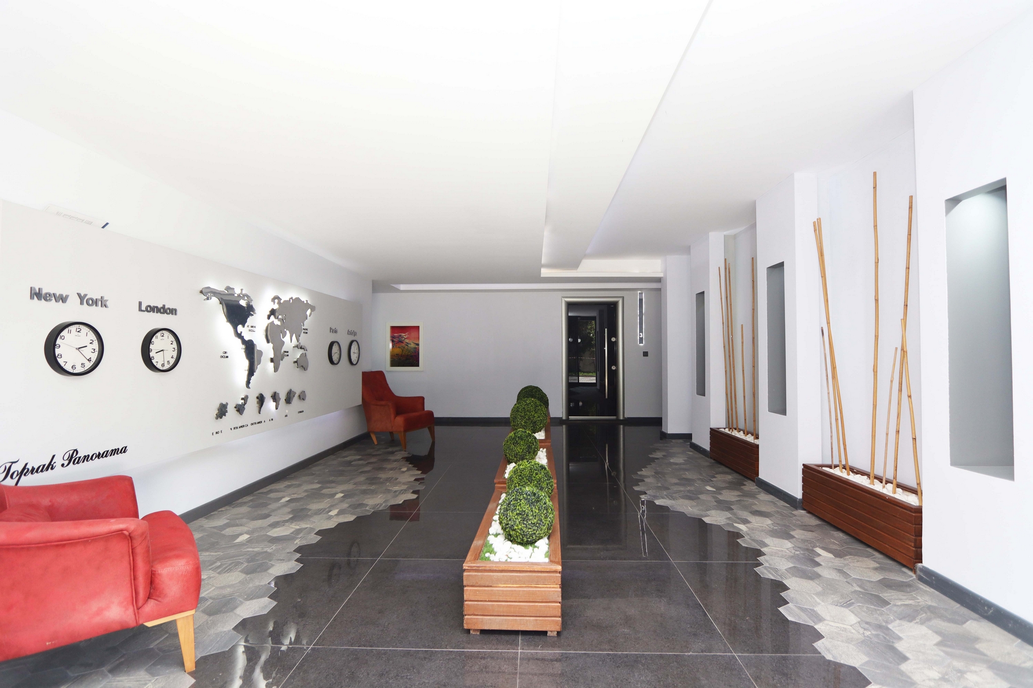 Lobby with a glossy dark floor, red armchair and world map where homes are for sale