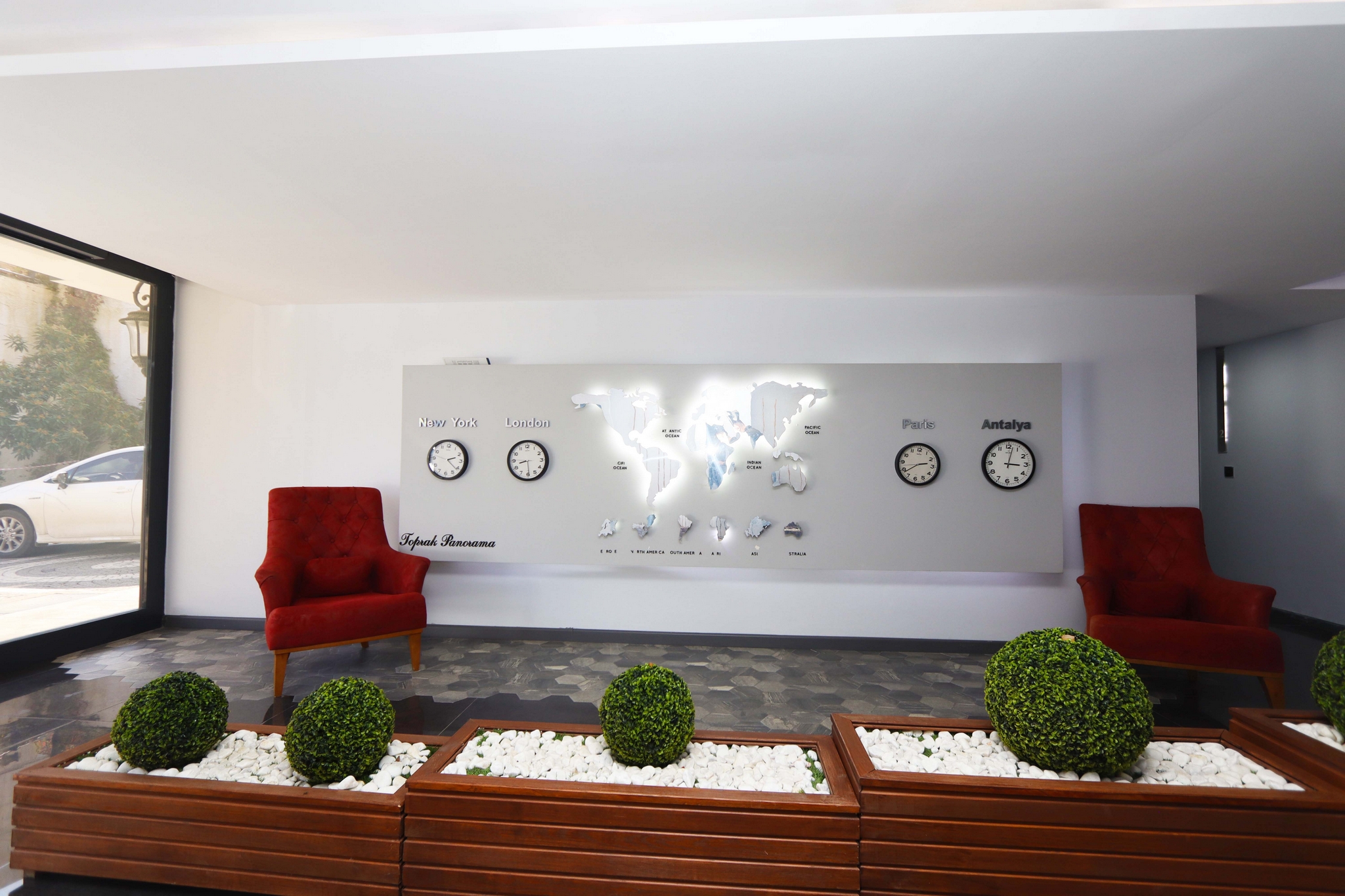 Lobby with red armchairs, a world map and panoramic window in a complex with apartments