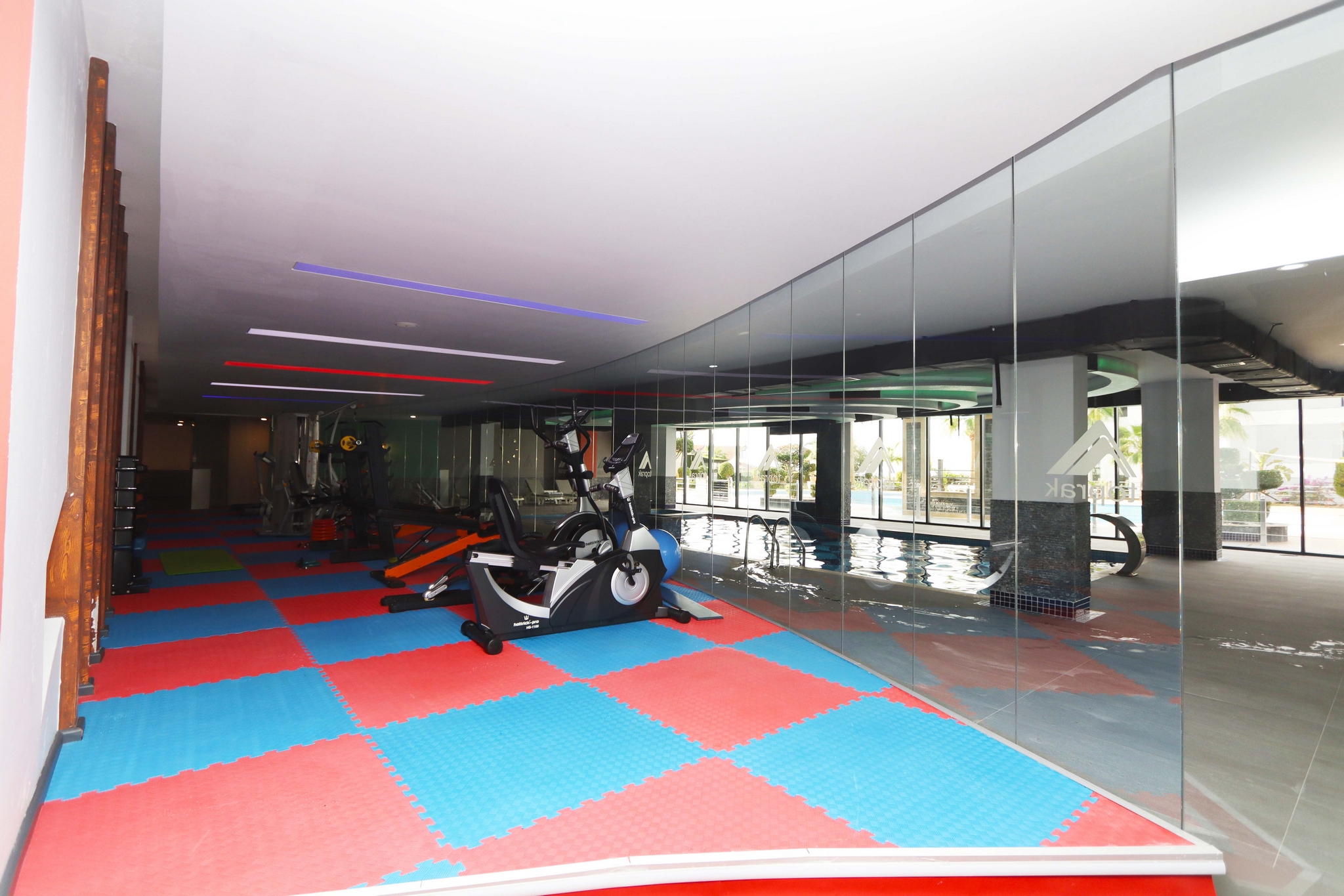 Sports area with an exercise bike, floor mats and mirrored wall for residents of apartments in Kargicak