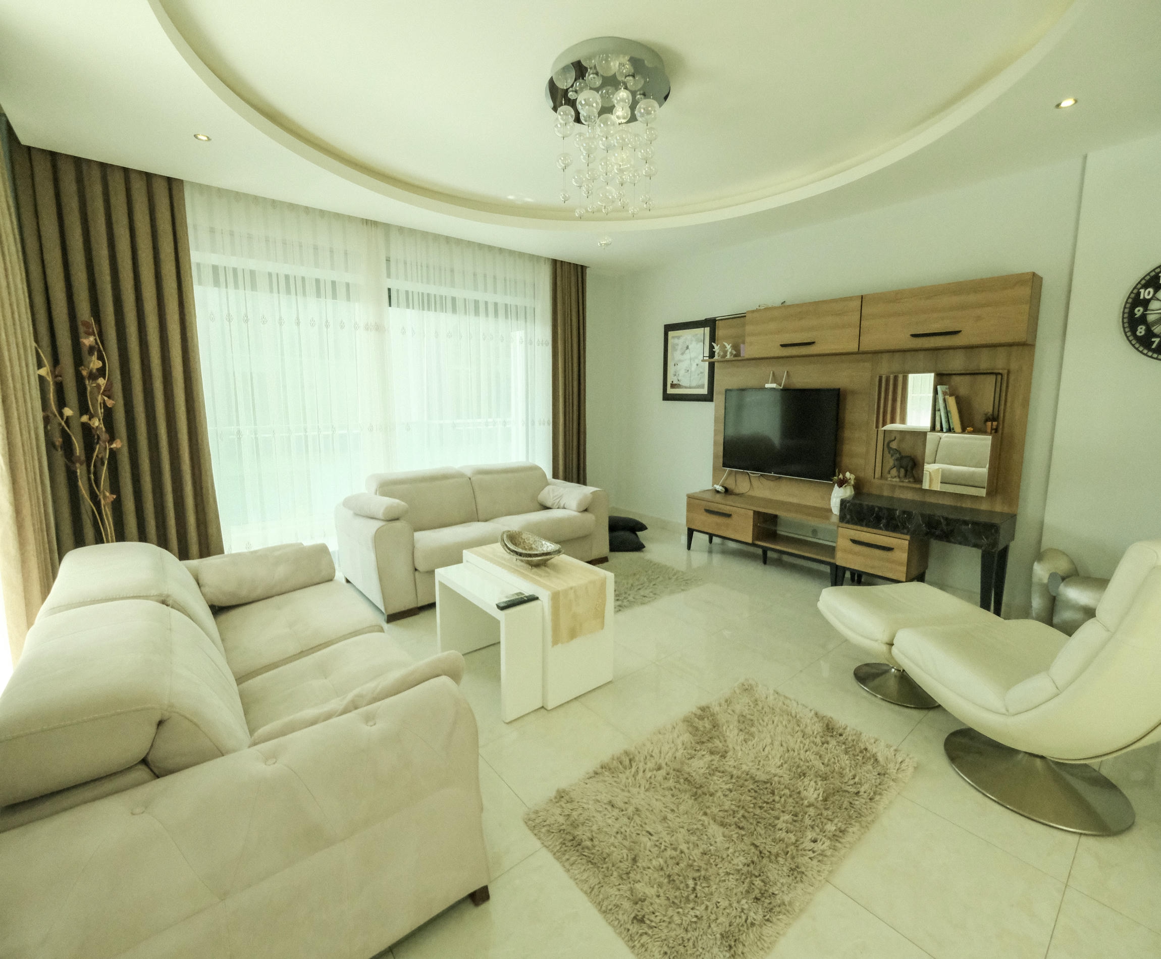 Living room with white sofas and a panoramic window in a 3+1 apartment in Kargicak for sale