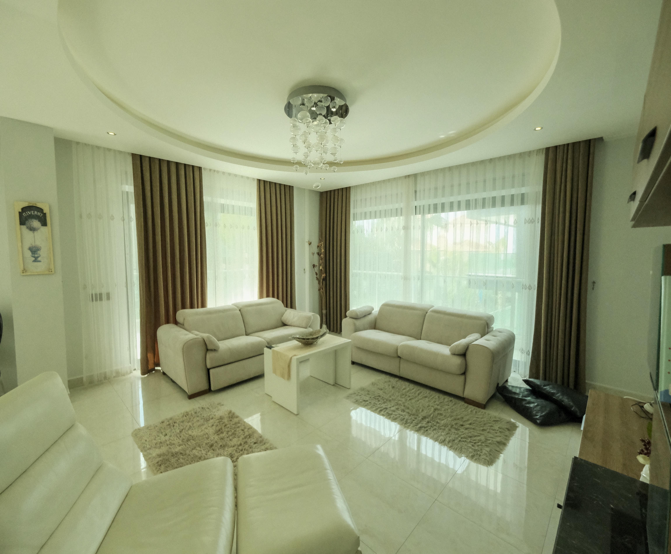 Living room with white sofas and corner panoramic windows in an apartment in Turkey