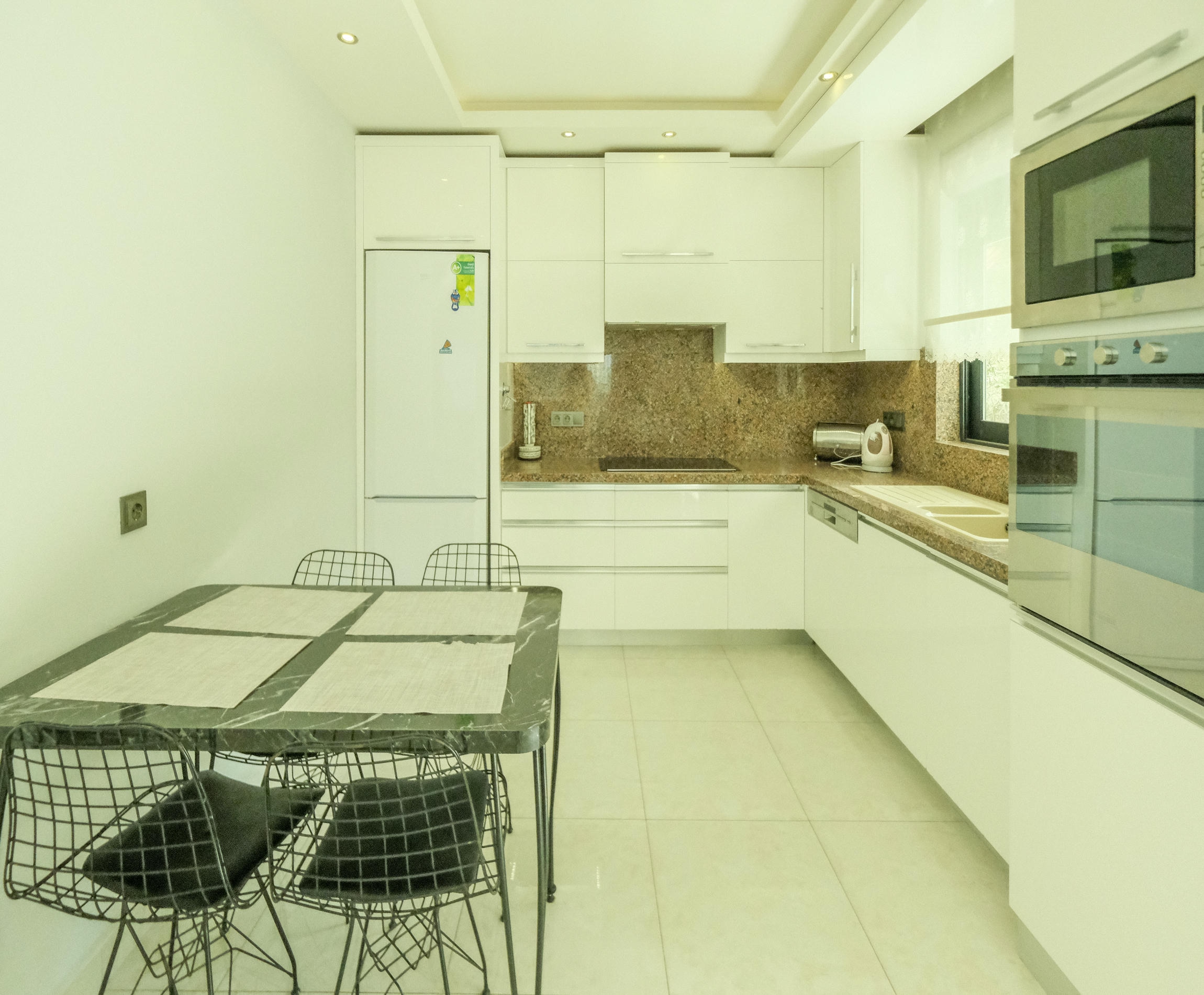 Kitchen with white cabinetry and built-in appliances in a 3+1 apartment in Kargicak