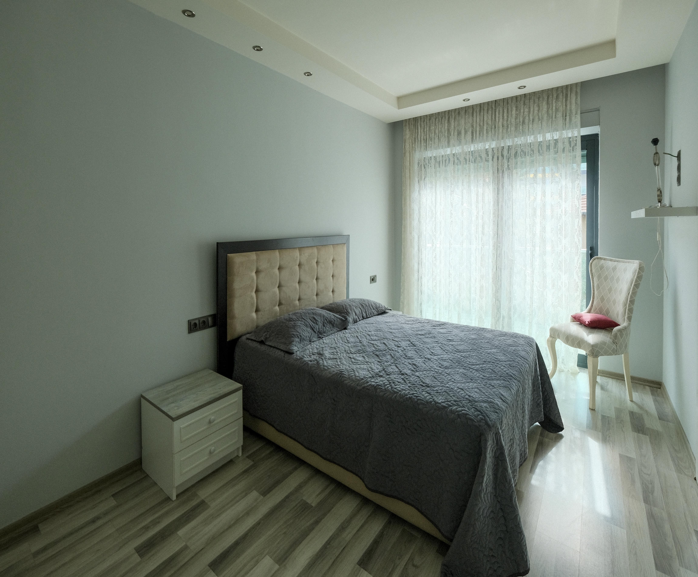 Bedroom with a double bed and panoramic window in an apartment in Kargicak