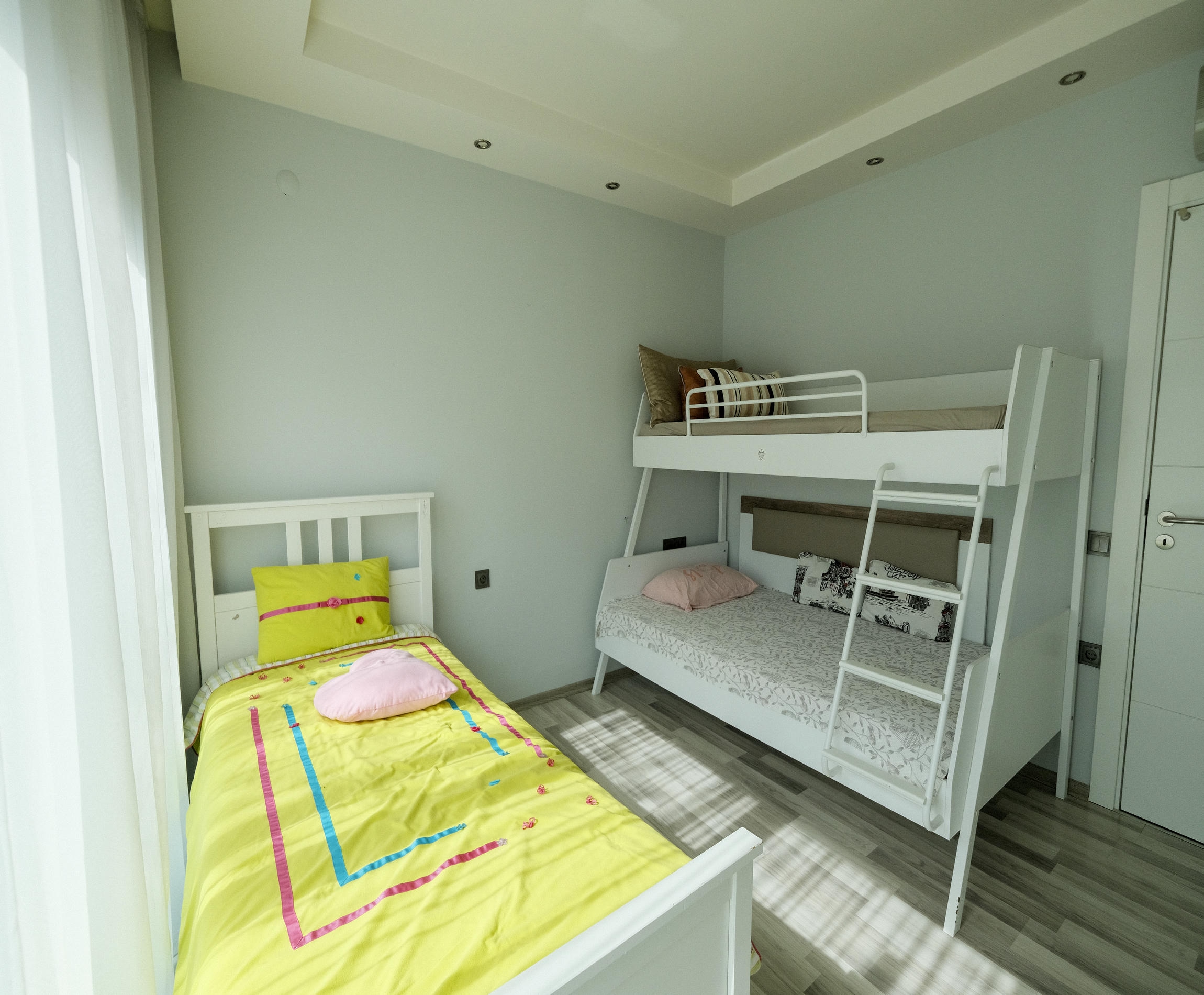 Children's bedroom with single and bunk beds in an apartment