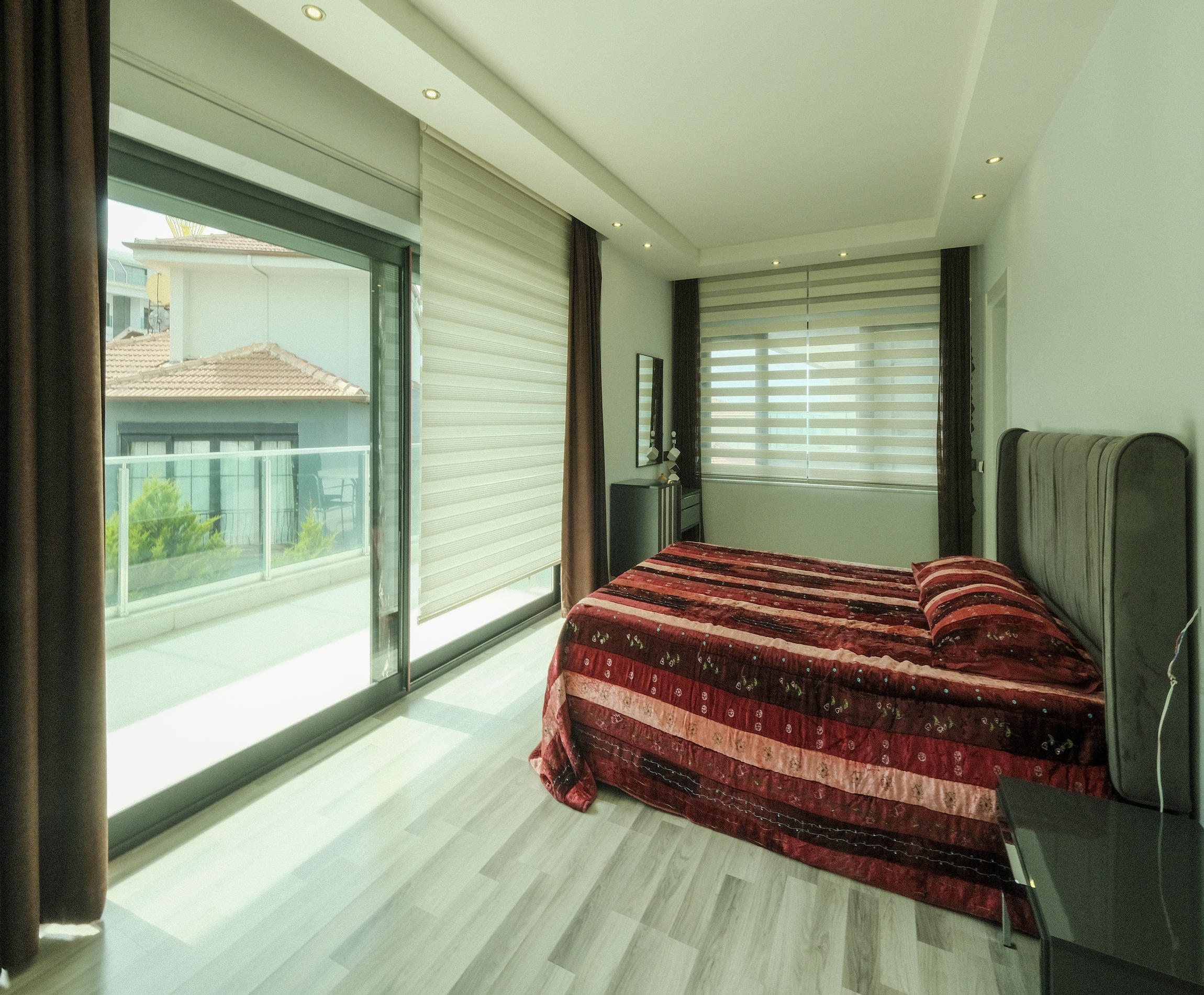Bedroom with a double bed and panoramic balcony door in Kargicak