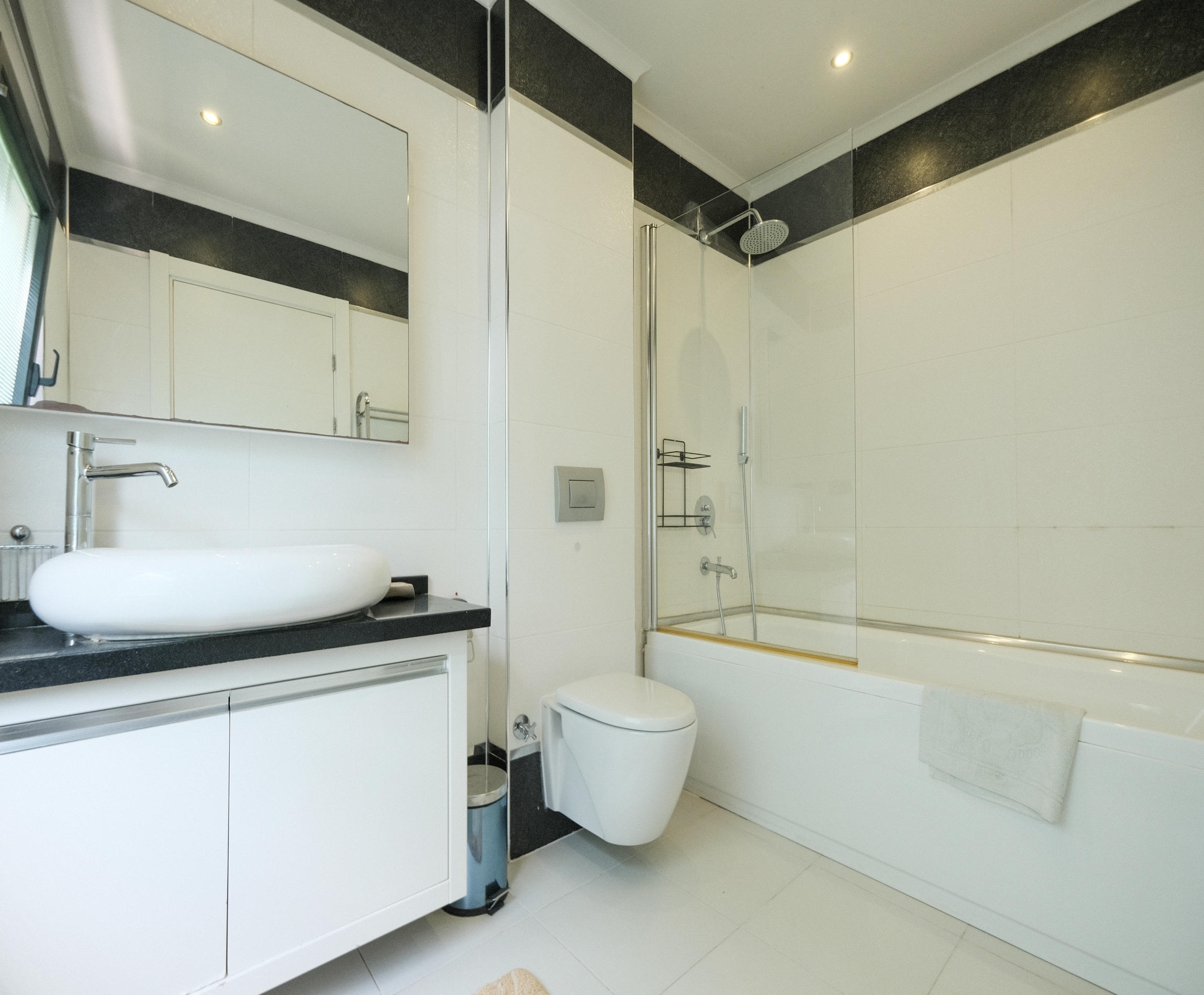 Bathroom with a bathtub behind a glass partition in an apartment