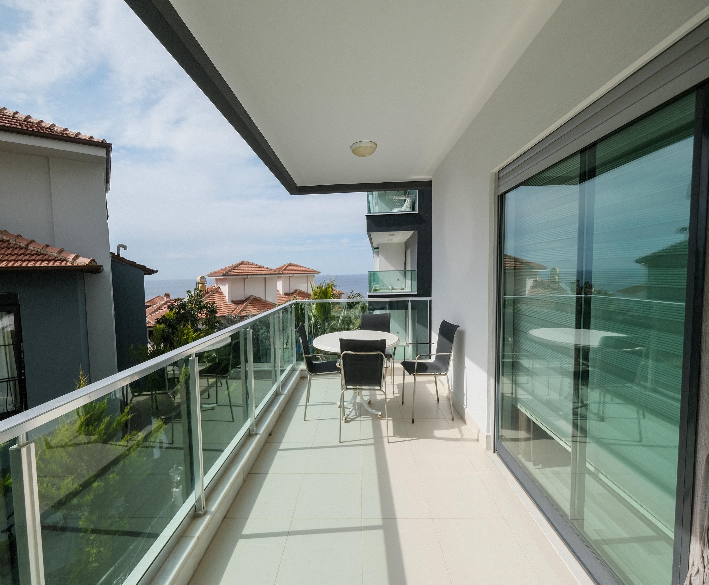 Spacious terrace with glass railing and panoramic glazing at a 3+1 apartment for sale in Kargicak
