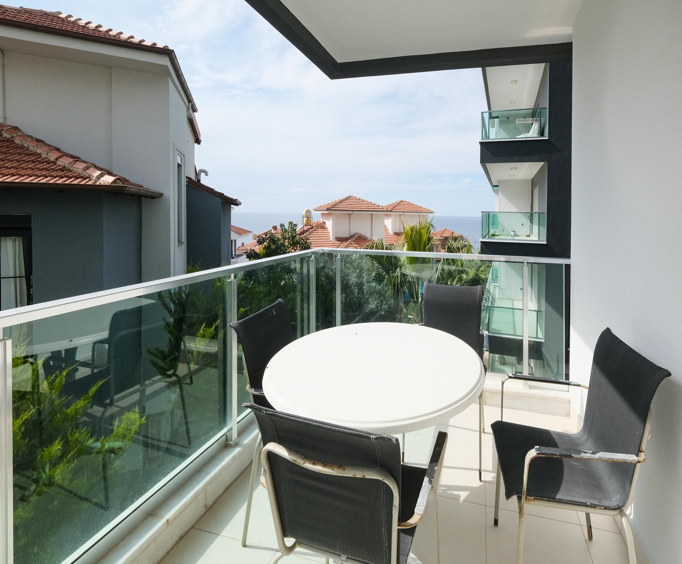 Balcony with glass railing, outdoor seating and sea views for sale