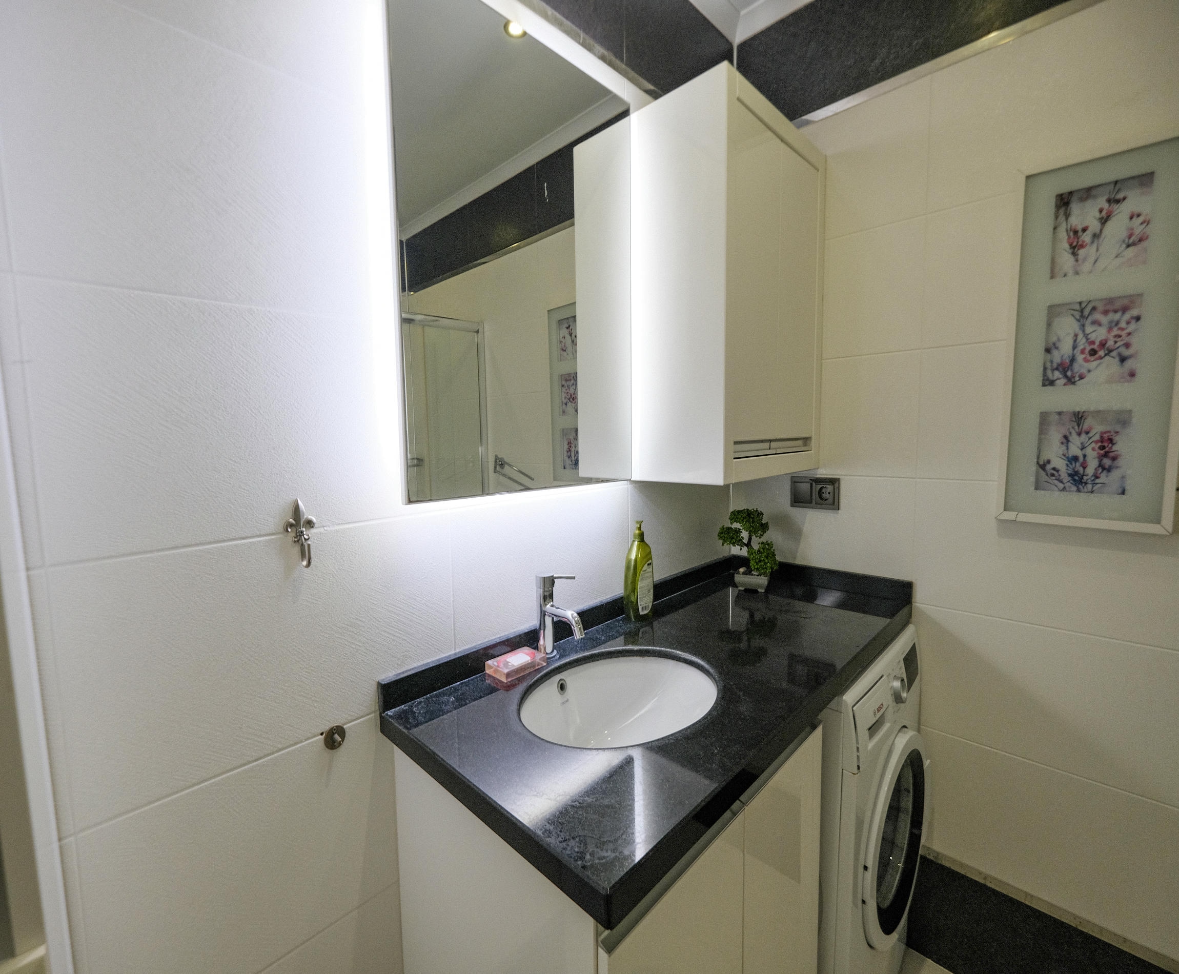 Laundry room with a sink and washing machine in an apartment in Kargicak