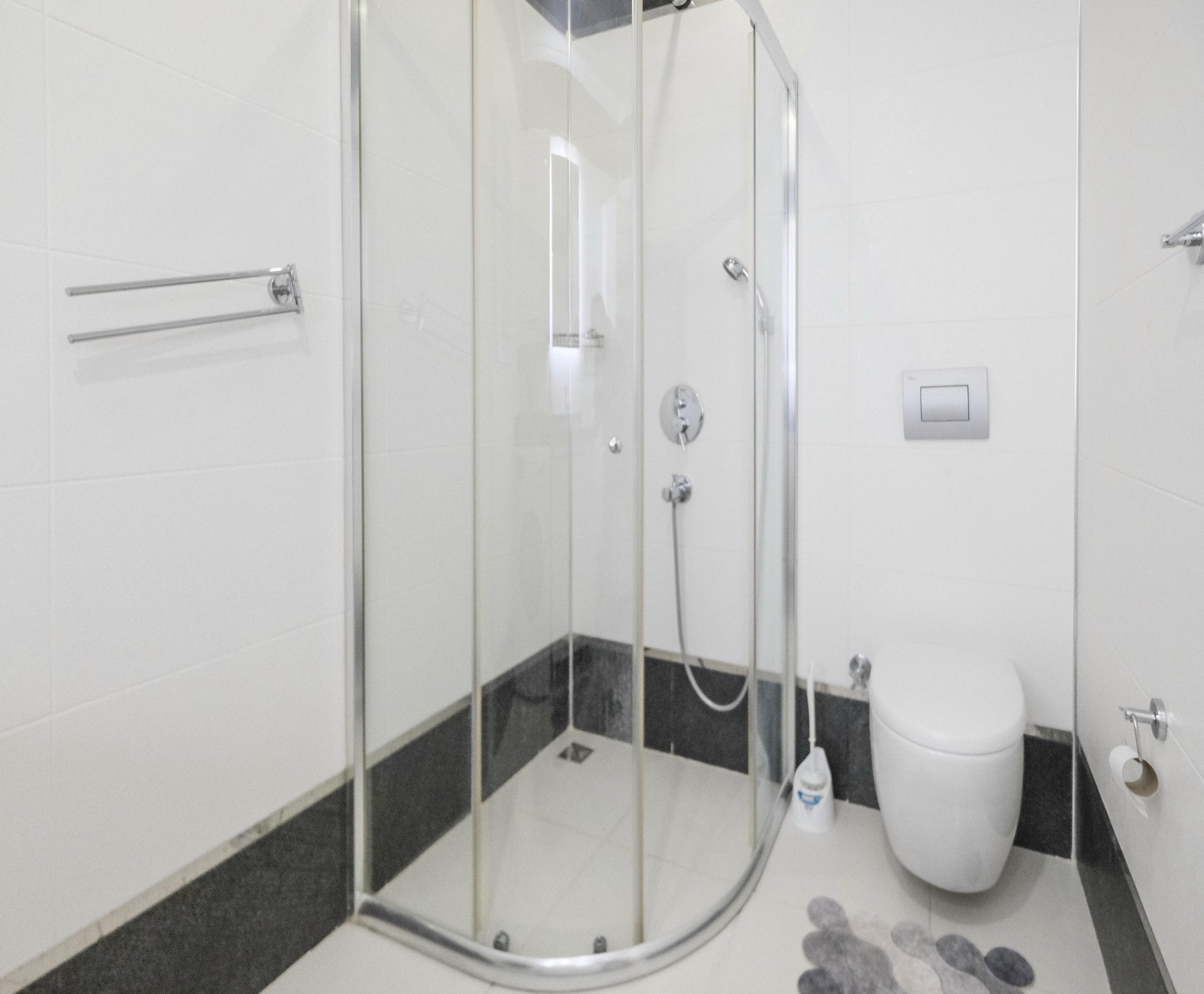 Bathroom with a glass shower enclosure and wall-mounted shower in an apartment
