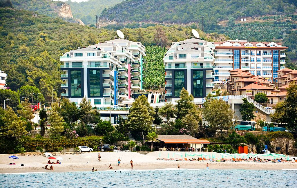 Kargıcak'ta deniz kenarındaki komplekste turkuaz sulu çakıllı plaj ve şezlonglar