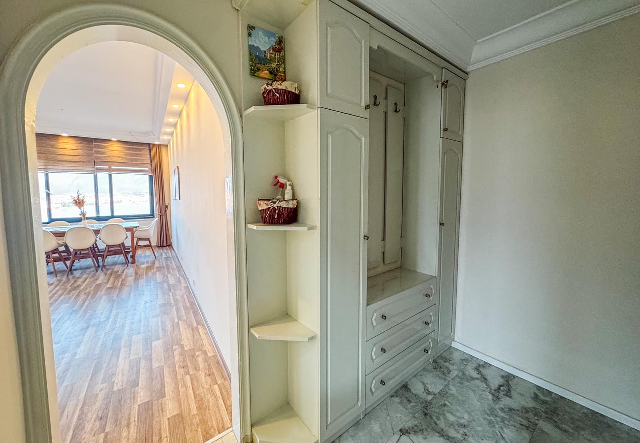 Walk-in wardrobe with built-in cabinets, drawers and marble flooring in an apartment