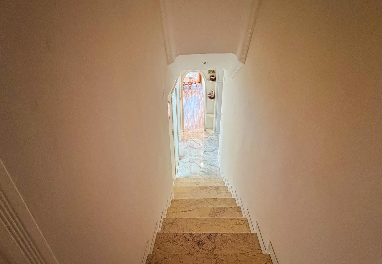 Interior staircase with marble steps, arched doorway and decorative niches in an apartment in Alanya