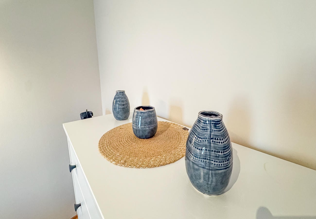White chest with ceramic vases and a woven tray in a residence in Alanya