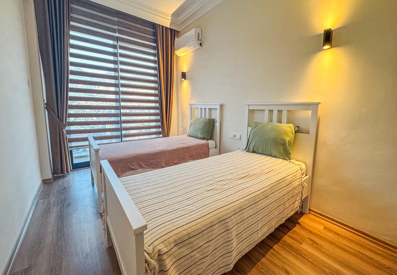 Bedroom with two single beds, patterned covers and a panoramic window