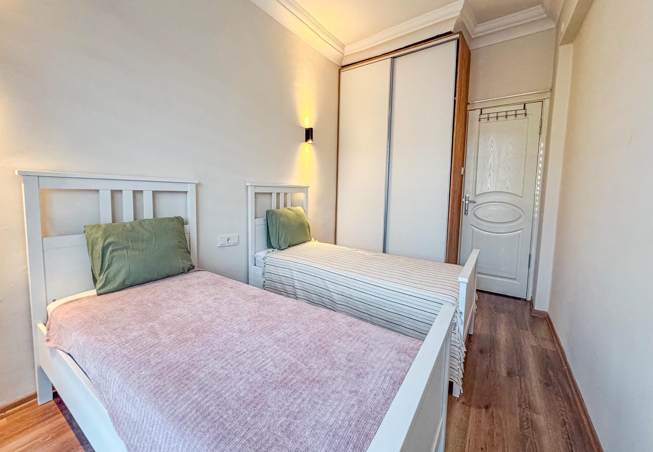 Bedroom with two beds, built-in wardrobe and sliding doors in an apartment