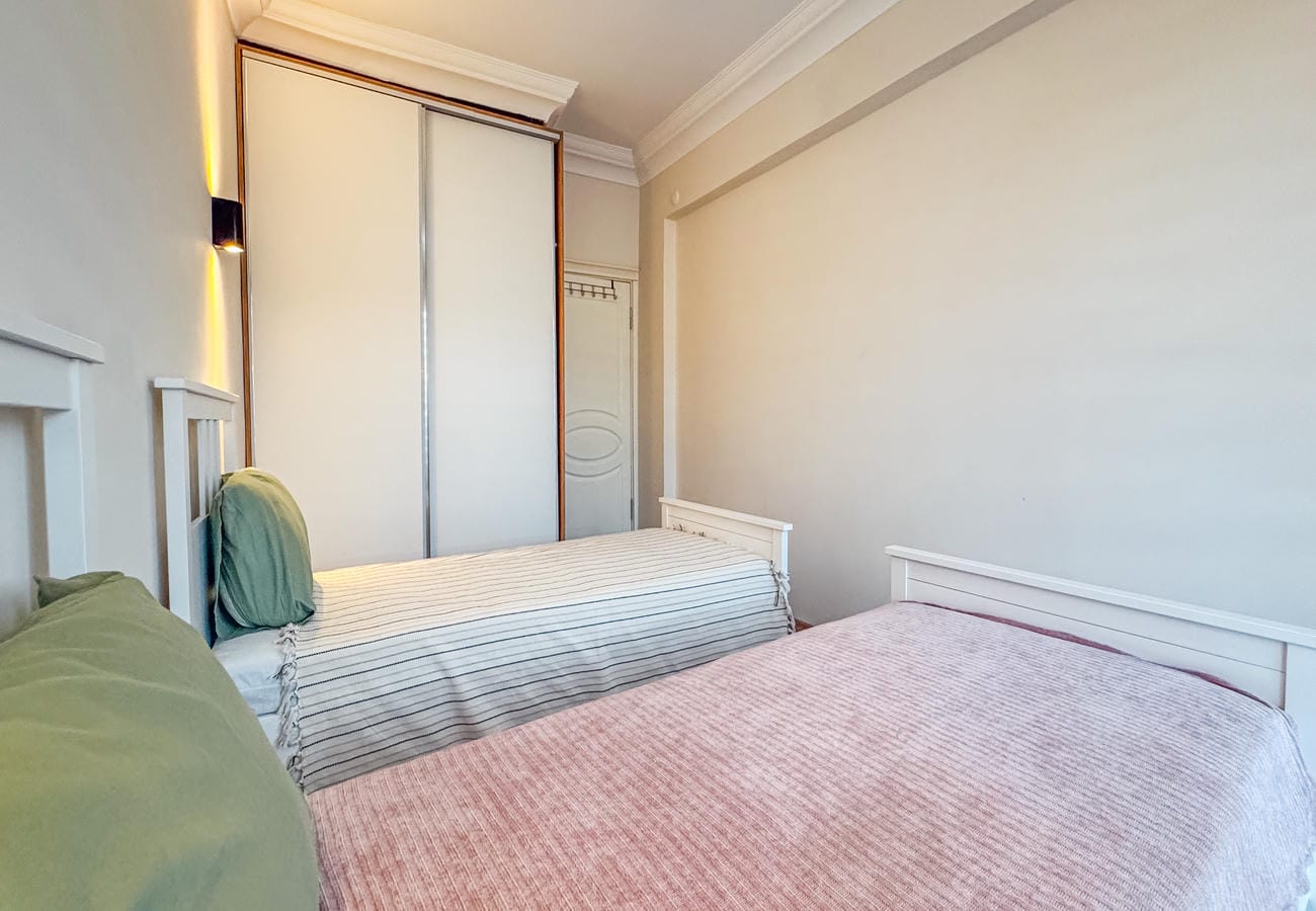 Bedroom with two beds and a built-in wardrobe with sliding doors in Alanya