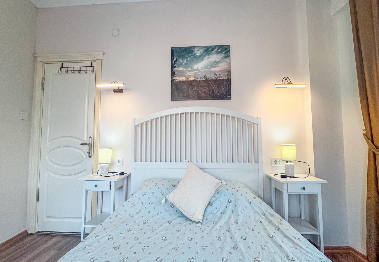 Bedroom with a double bed, bedside tables and a patterned light cover in an apartment