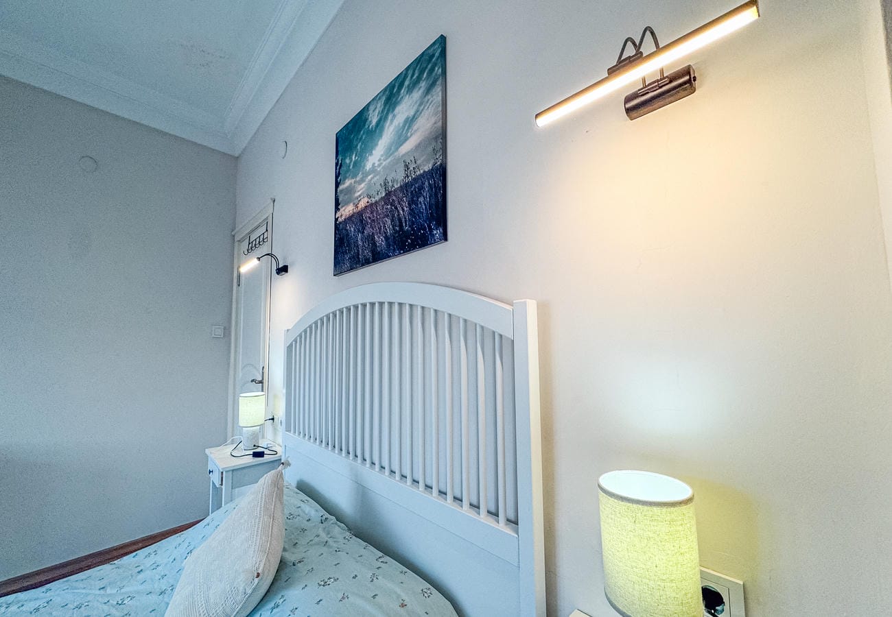 Bedroom with a double bed, tall white headboard and wall picture in Alanya