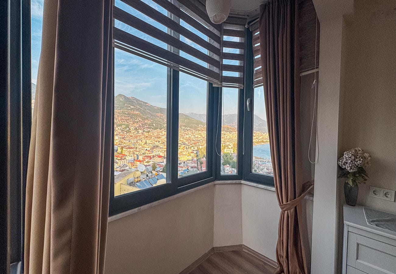 Corner panoramic glazing overlooks a mountain slope and cityscape in Türkiye