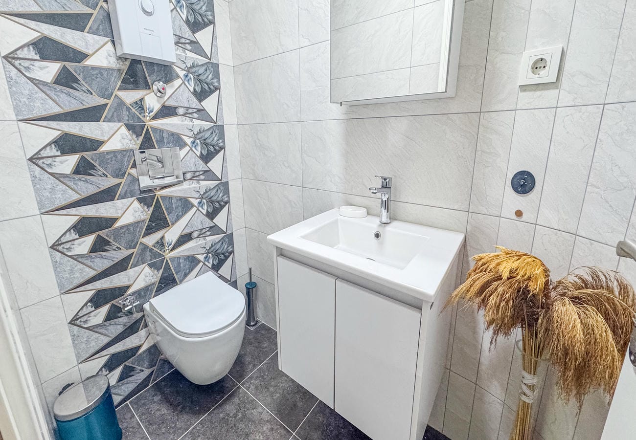 Bathroom with wall-hung toilet, vanity basin and geometric tile in a flat