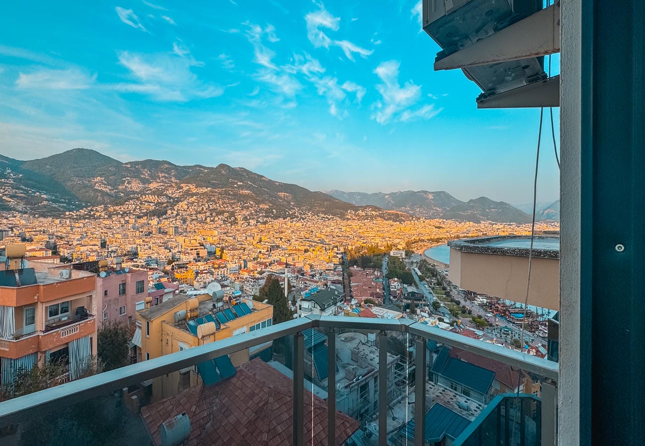Mountain city and curved shoreline seen from a balcony present apartments for sale