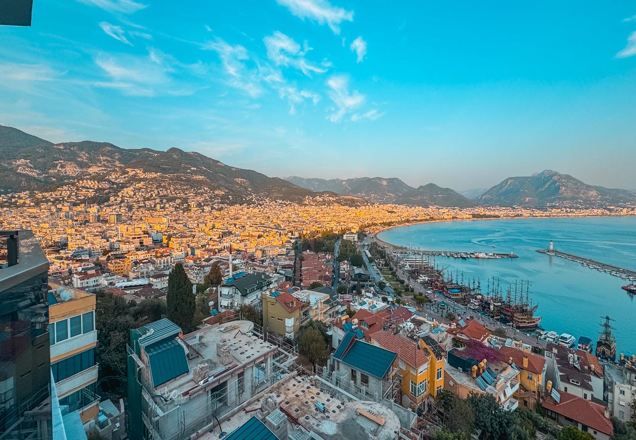 Bay panorama with mountain peaks, piers and boats across Alanya in Türkiye