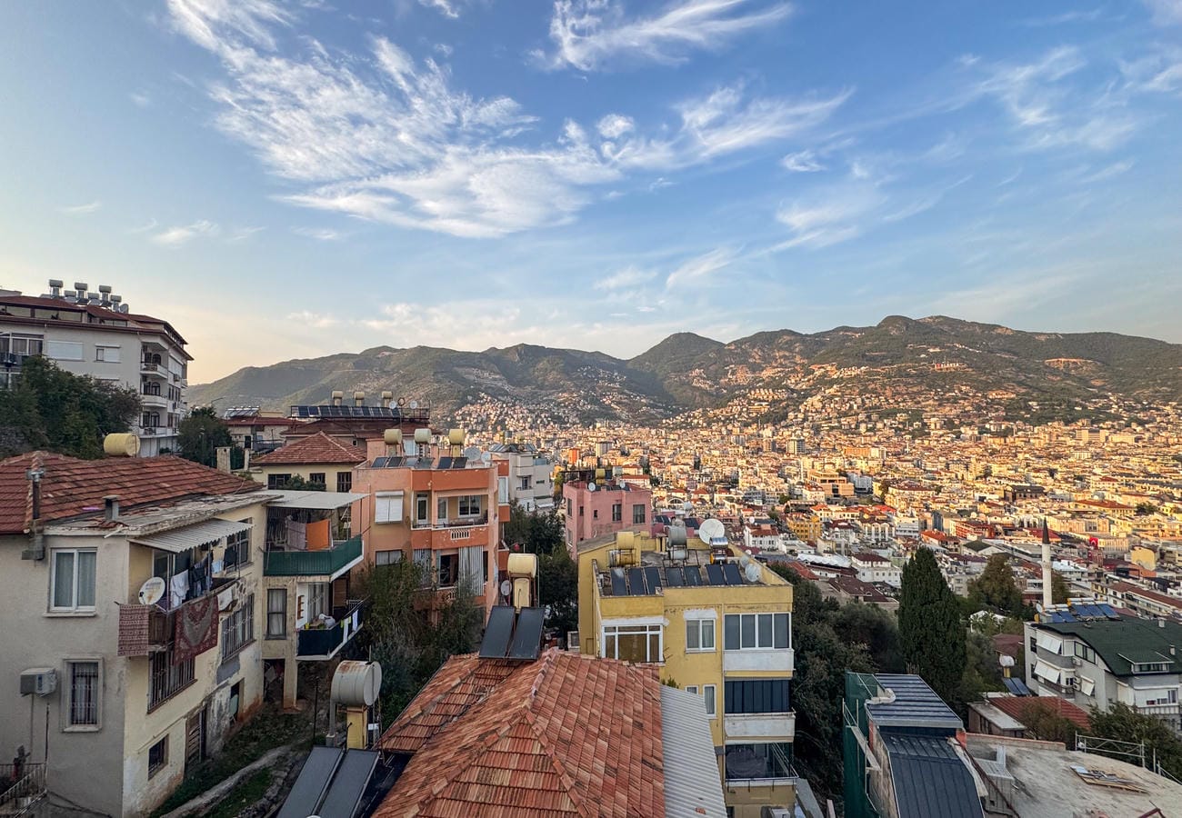 Mountain ridge above hillside homes and red tile roofs at a residential complex with apartments in Alanya