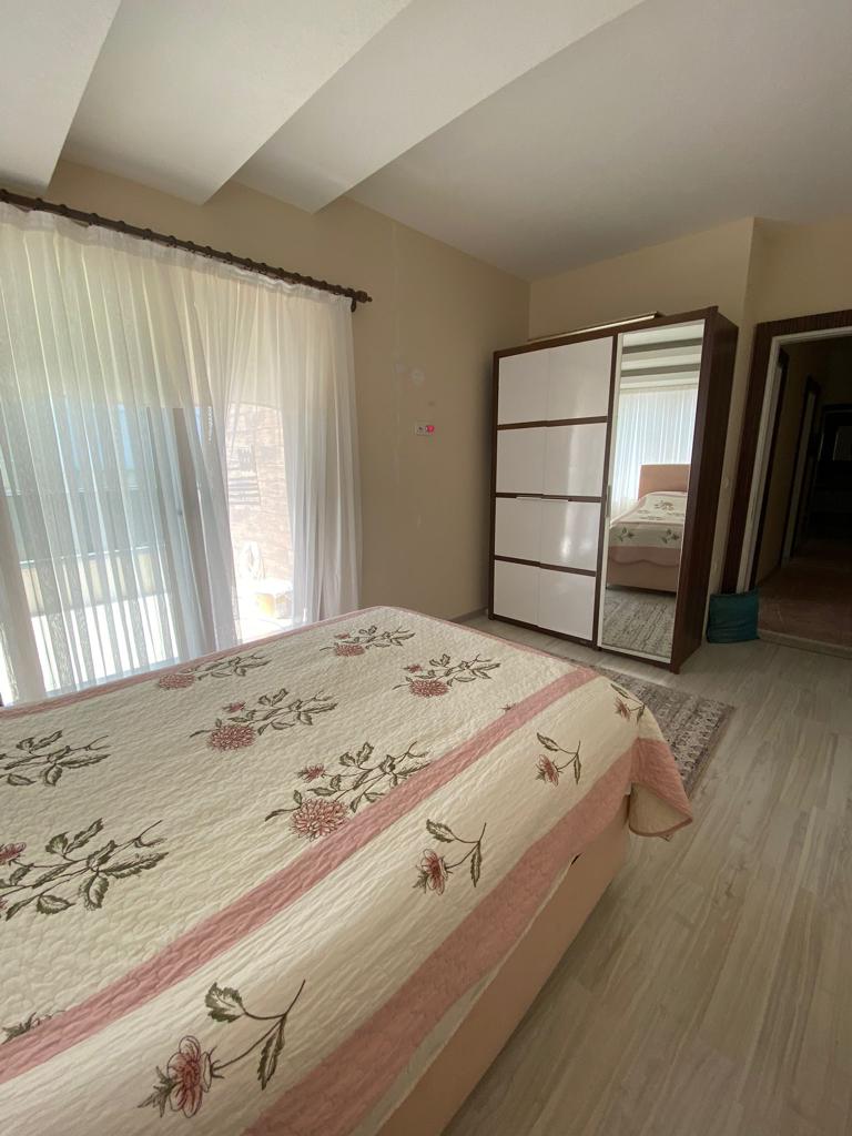 Aynalı gardıroplu yatak odasında Alanya’daki çatı katı dairenin çift kişilik yatağı ve balkon kapısı
