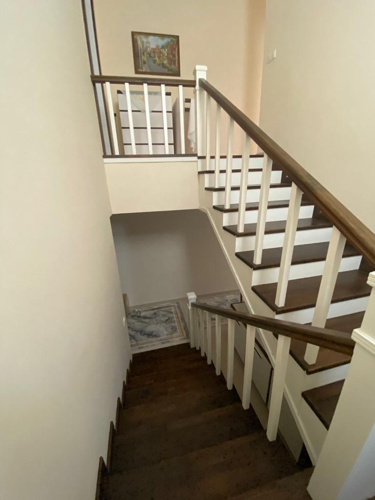 Alanya’daki penthouse iç merdiveninde ahşap basamaklar, beyaz korkuluk ve duvar resmi