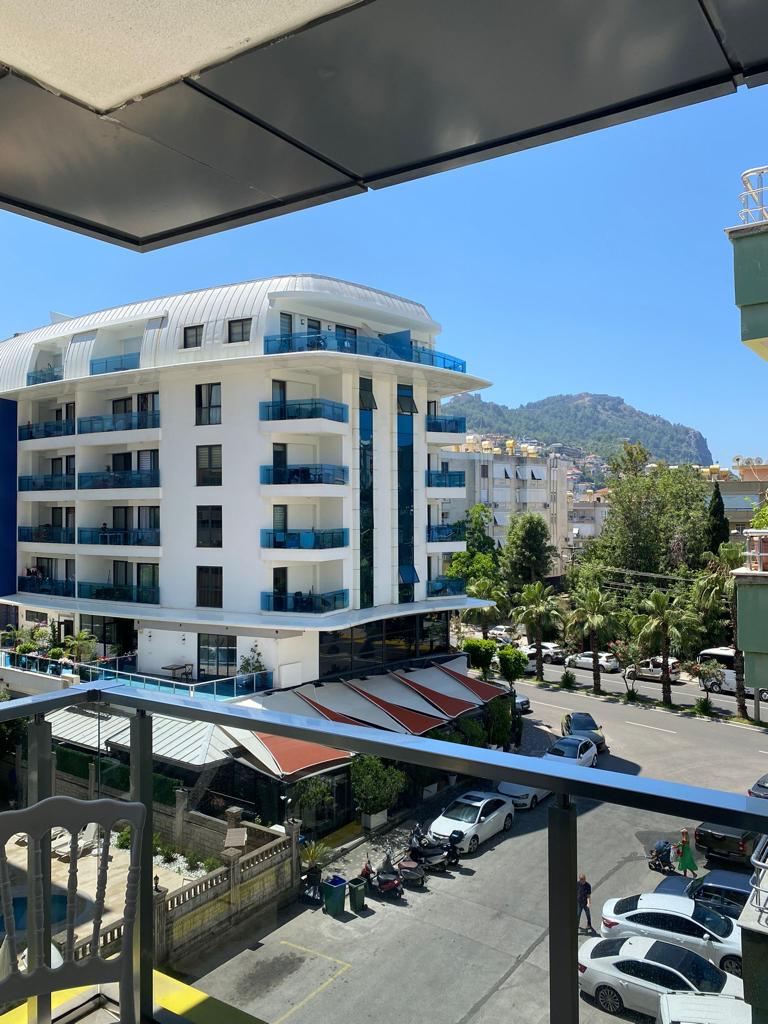 Dağ yamacına bakan cam korkuluklu balkon Türkiye’de satışta olan dairenin açılır tentesiyle