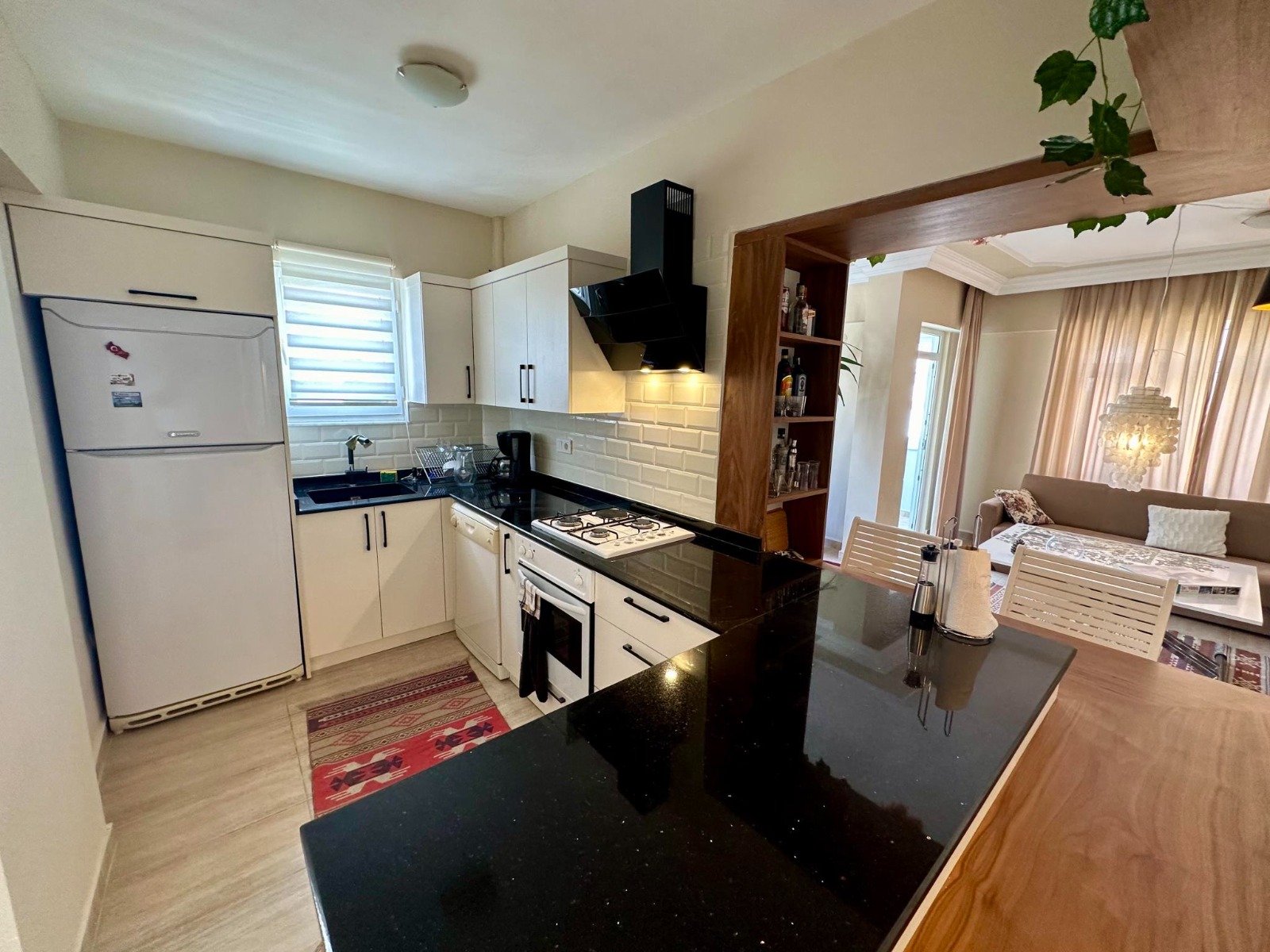 White cabinets, a black countertop and a gas cooktop define the kitchen of a 4+1 duplex in Alanya