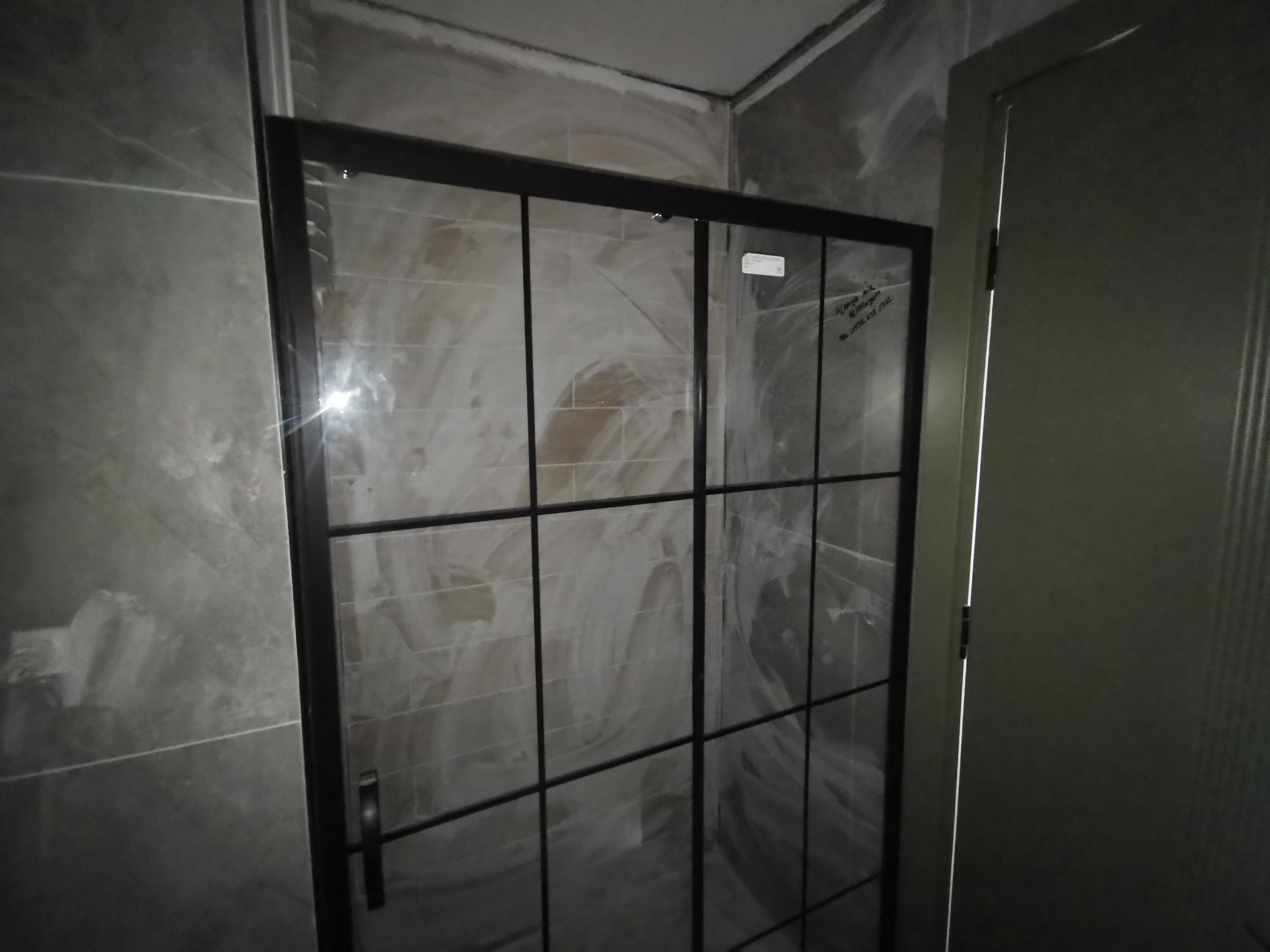 Ванная со стеклянной душевой перегородкой и серой плиткой под камень в Авсалларе