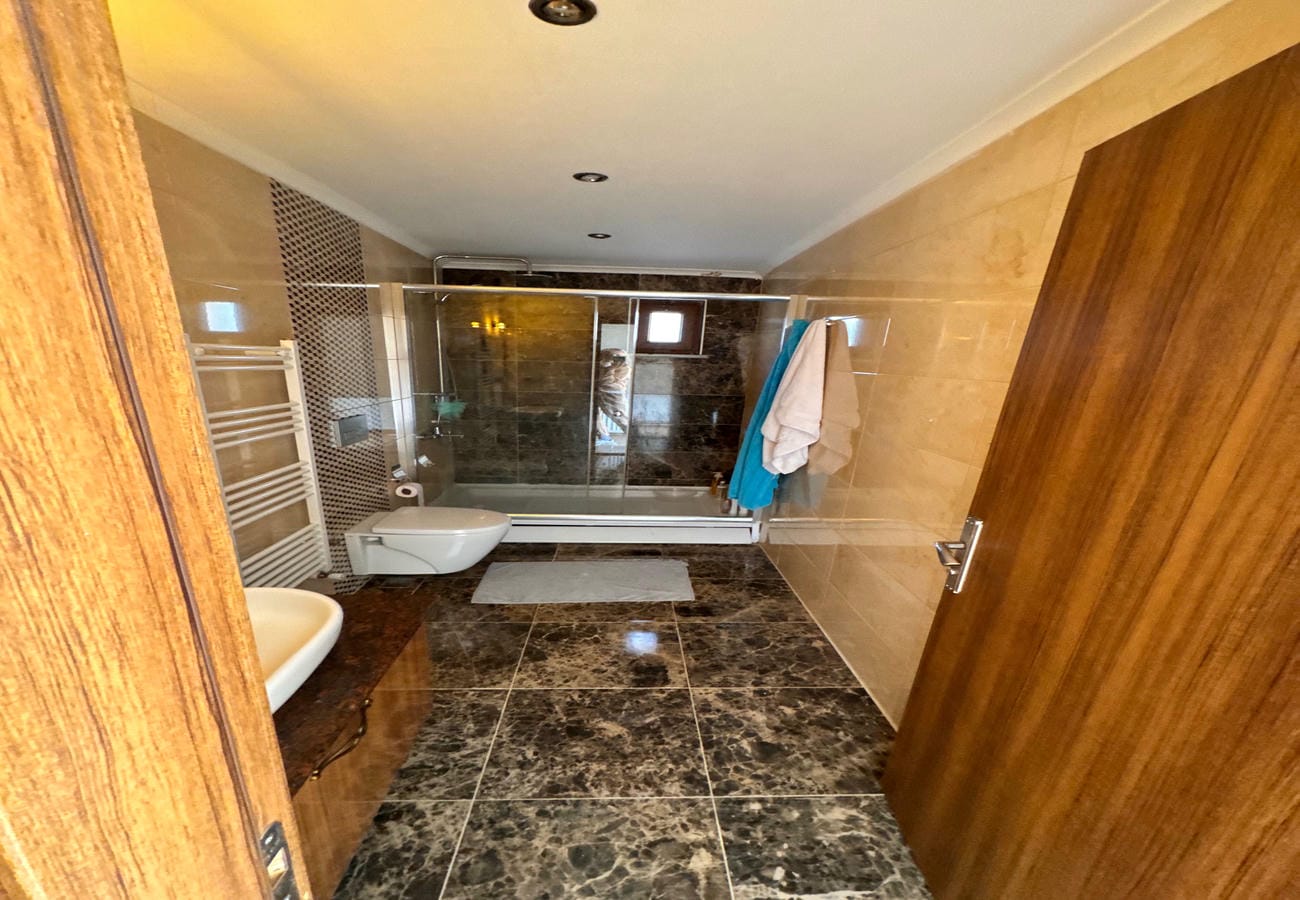 Tam duvar cam duşakabinli banyo, Alanya’daki daire rezidansında yer alıyor