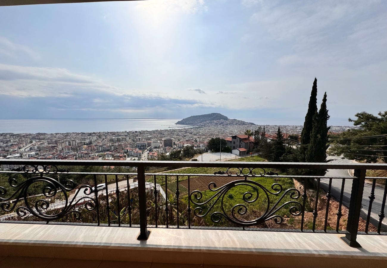 Dairenin balkonundan deniz koyu, yeşil yamaç ve şehir manzarası Alanya’da