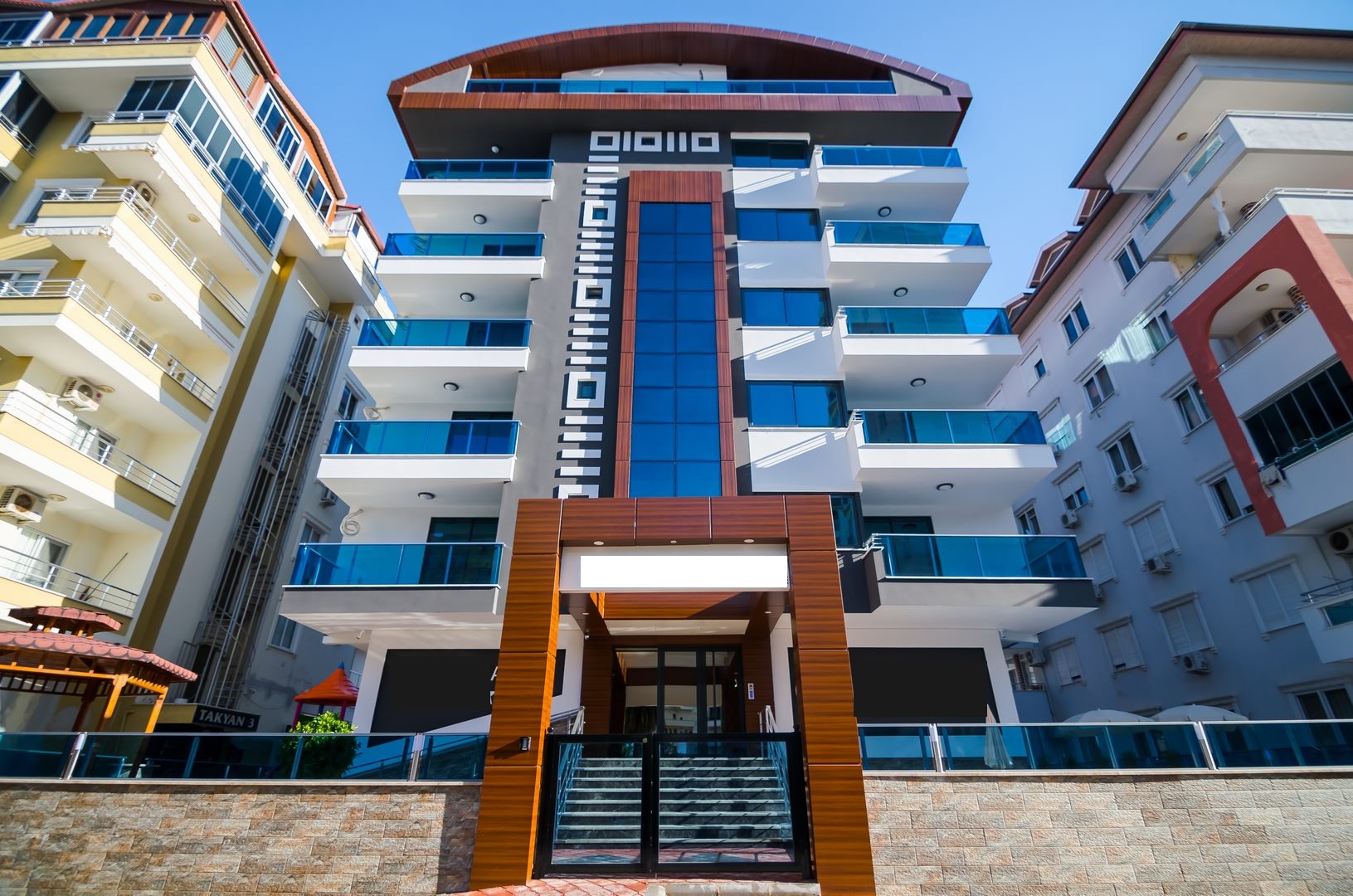 Mavi cam panelli girişte taş kaplama kaide ve merdiven, Türkiye’de satılık konut için