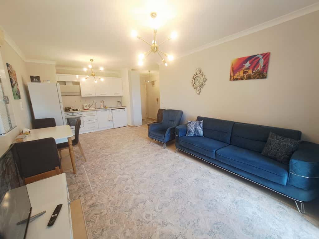 Koltuk, TV ünitesi ve yemek masalı mutfak-oturma odası, apartman dairesinde